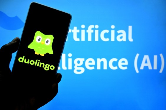 Duolingo logo on smartphone screen with green owl mascot and text 'Artificial Intelligence (AI)' in the background