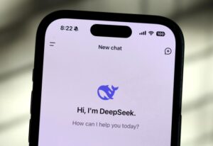 Smartphone screen displaying the DeepSeek app with logo and greeting, highlighting the new R1 distilled AI model for enhanced efficiency