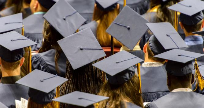 Group of graduates wearing mortarboards and gowns at a graduation ceremony, symbolizing new beginnings in the evolving tech industry influenced by AI.