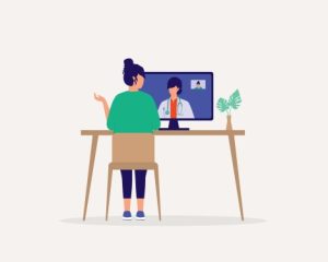 Person having a virtual consultation with a doctor on a computer screen at a desk
