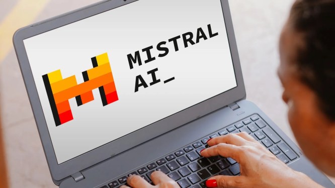 Person using laptop showing logo of 'MISTRAL AI'