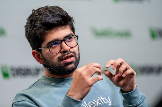 Person with glasses and beard speaking or gesturing, with TechCrunch background, discussing AI search engine query growth