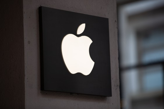 Illuminated Apple logo displayed on a wall, symbolizing Apple's presence in the tech industry amidst AI advancements